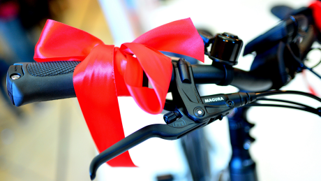 Ein Fahrrad mit einer roten Schleife am Lenker