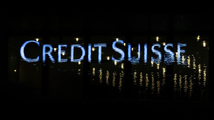 Das Logo der Schweizer Bank Credit Suisse spiegelt sich in einer Pfütze in Zürich © Michael Buholzer/KEYSTONE/dpa