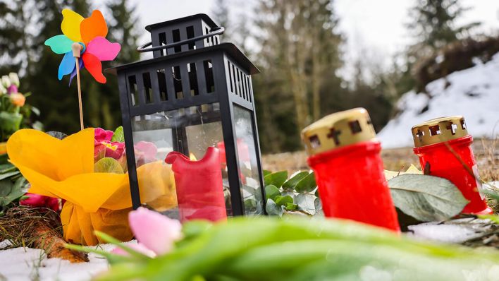 Kerzen und Blumen liegen in einem Wald im südlichen Nordrhein-Westfalen und erinnern an das getötetet zwölfjährige Mädchens aus Freudenberg © dpa/Oliver Berg