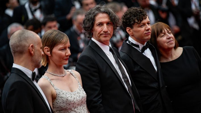 James Wilson (l-r), Filmproduzent aus den USA, Sandra Hüller, Schauspielerin aus Deutschland, Jonathan Glazer, Regisseur aus Großbritannien, Christian Friedel, Schauspieler aus Deutschland und Ewa Puszczynska, Filmproduzentin aus Polen, kommen zur Premiere des Films "The Zone of Interest" bei den 76. internationalen Filmfestspielen in Cannes © Daniel Cole/AP/dpa