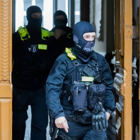 Polizisten kommen bei einer Hausdurchsuchung in Berlin-Kreuzberg aus einem Gebäude © dpa/Christoph Soeder