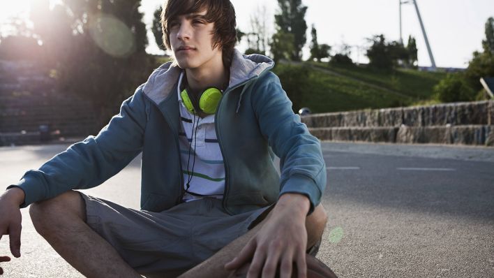 Teenager mit Basketball und Kopfhörern © IMAGO / Westend61