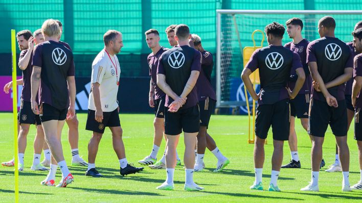 Bundestrainer Hansi Flick steht mit dem Team auf dem Trainingsplatz © dpa/Julian Stratenschulte