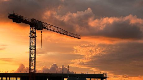 Silhouette eines Baukrans bei Sonnenaufgang © imago images/Frank Sorge