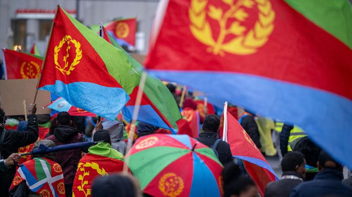 Participants in the demonstration organized by the Central Council of Eritreans in Germany march through Berlin with flags and signs © dpa/Monika Skolimowska