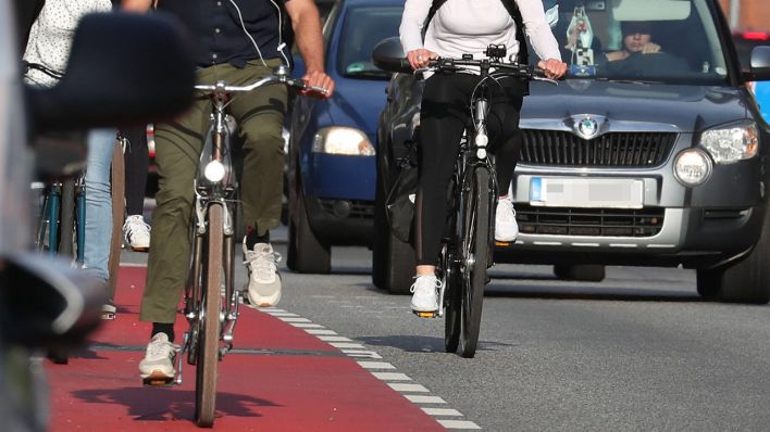 Eine Radfahrerin überholt Radfahrende © imago images/localpic