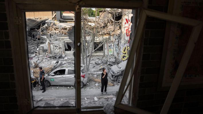 Israelis inspizieren am 08.10.2023 die Trümmer eines Gebäudes in Tel Aviv © AP/Oded Balilty