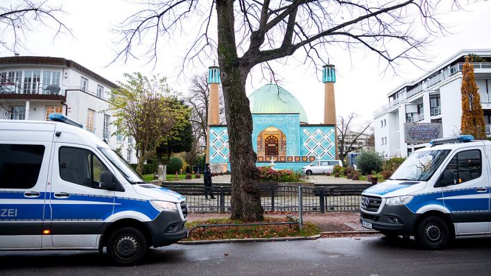 Einsatzkräfte der Polizei stehen während einer Razzia beim islamischen Zentrum Hamburg vor der Imam Ali Moschee (Blaue Moschee) an der Außenalster © dpa/Daniel Bockwoldt