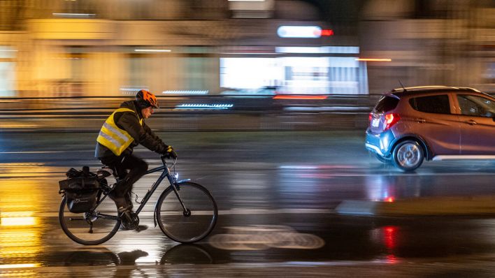Ein Fahrradfahrer fahren auf der abendlichen Schönhauser Allee in Berlin © IMAGO/Seeliger