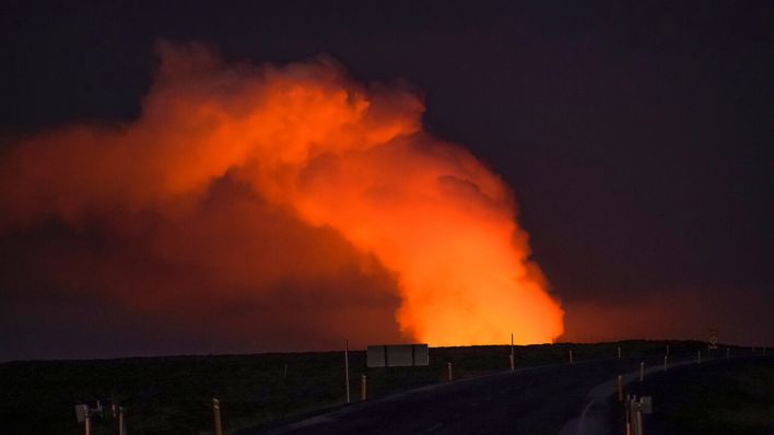 Blick auf die Gaswolke, die von der Lava des ausbrechenden Vulkans beleuchtet wird, von einer Straße aus gesehen, die nach Grindavik in Island führt © AP Photo/Marco Di Marco