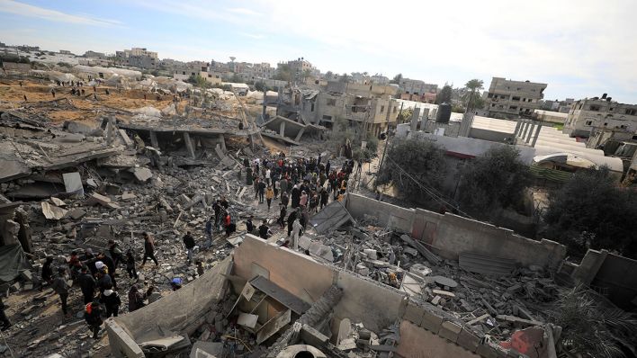 Palästinenser durchsuchen die Trümmer von Gebäuden in Rafah im Gazastreifen, die durch israelische Luftangriffe beschädigt wurden © Yasser Qudih/XinHua/dpa