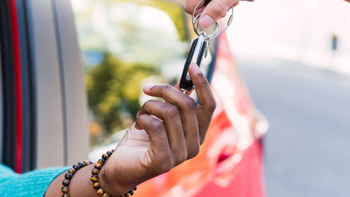 Frau nimmt einen Autoschlüssel entgegen © IMAGO / Westend61