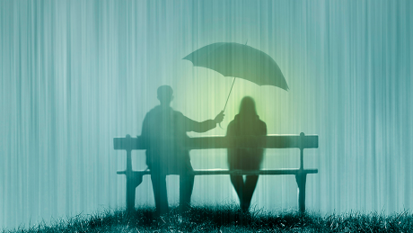 Ein Mann hält im Regen einen Schirm über eine Frau © IMAGO / Westend61