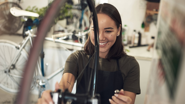 Eine Mechanikerin in einem Fahrrad-Shop © IMAGO / Zoonar