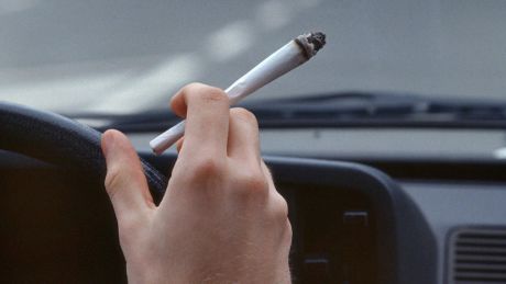 Ein Autofahrer raucht einen Joint während der Autofahrt © imago images/Rupert Oberhäuser