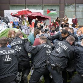 Polizeibeamte gehen während propalästinensischen Demonstration der Gruppe "Student Coalition Berlin" auf dem Theaterhof der Freien Universität Berlin gegen Demonstranten vor © Sebastian Christoph Gollnow/dpa