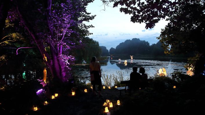 Festivalbesucher blicken auf den Finowkanal beim Inselleuchten Festival © imago/Martin Müller