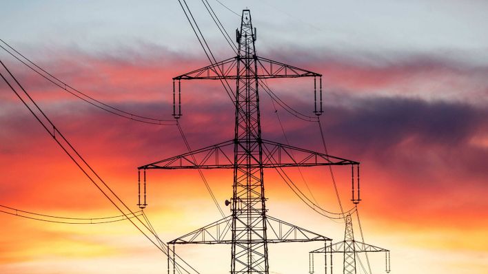 Hinter einem Strommast zeichnet sich der Abendhimmel ab (Symbolbild) © imago images/Daniel Scharinger