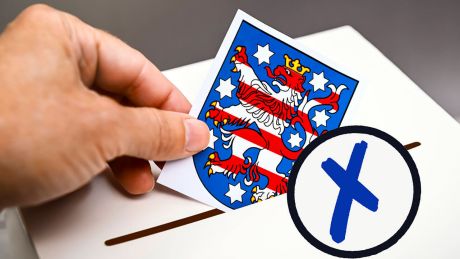 Bildmontage: Das Wappen von Thüringen wird in eine Wahlbox geworfen © IMAGO/Christian Ohde