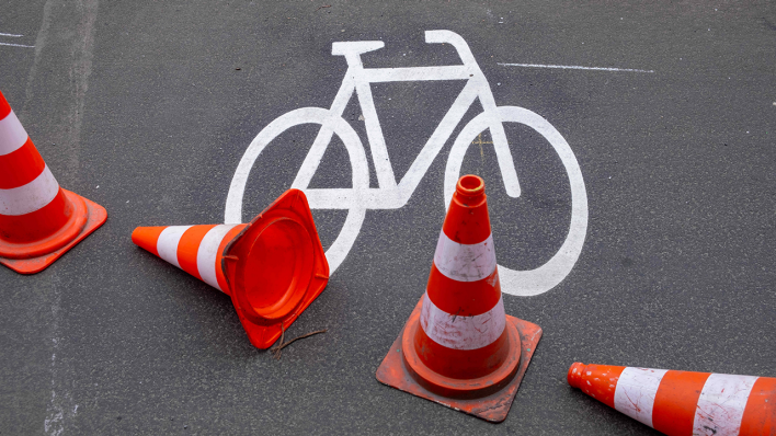 Leitkegel neben einem Fahrradsymbol auf einem Radweg © IMAGO / Seeliger