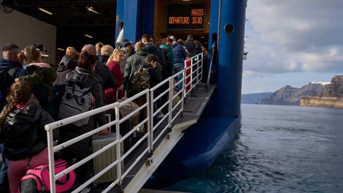 Passagiere besteigen eine reguläre Fähre zum Athener Hafen Piräus, nachdem ein Anstieg seismischer Aktivitäten die Besorgnis über ein potenziell starkes Erdbeben in Santorini ausgelöst hat © Petros Giannakouris/AP/dpa
