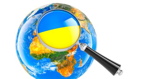 Ukrainische Flagge unter Lupe mit Globus ©IMAGO / Zoonar