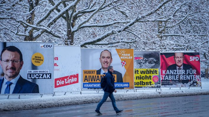 Schneebedeckte Bäume stehen hinter den Wahlplakaten verschiedener Parteien © dpa/Kay Nietfeld