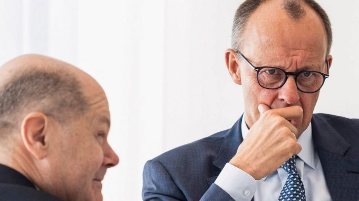 Der amtierende Bundeskanzler Olaf Scholz (SPD, li.) unterhält sich im Bundeskanzleramt mit dem künftigen Kanzler Friedrich Merz, Vorsitzender der CDU © Guido Bergmann/Bundesregierung/dpa