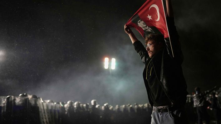 Ein Demonstrant steht in Istanbul mit einer Türkei-Flagge vor Polizisten © AP Photo/Francisco Seco