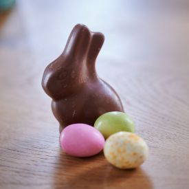 Ein ausgepackter Osterhase aus Schokolade und Schokoladeneier auf einem Tisch © dpa/Annette Riedl