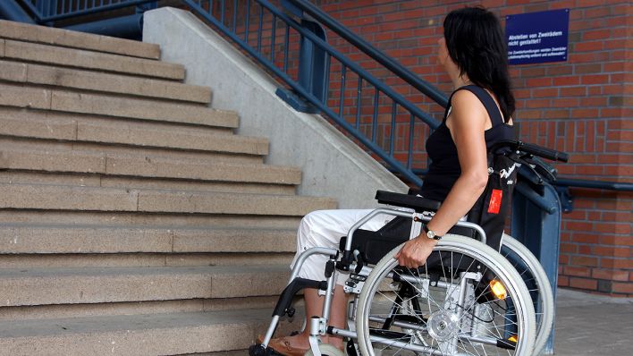 Frau im Rollstuhl an einer Treppe © IMAGO / blickwinkel