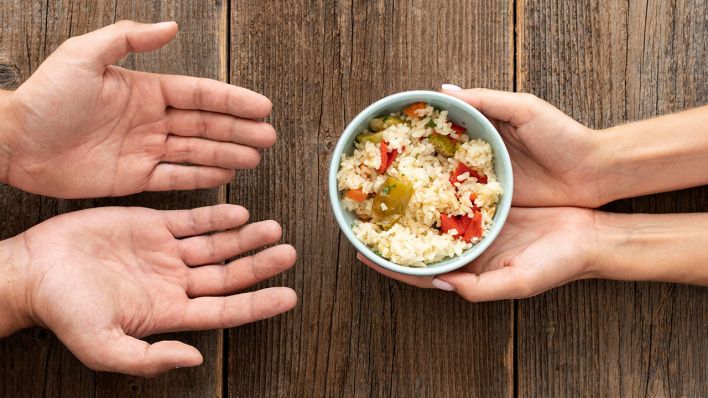 Hand gibt Schüssel Essen bedürftige Person © IMAGO / imagebroker