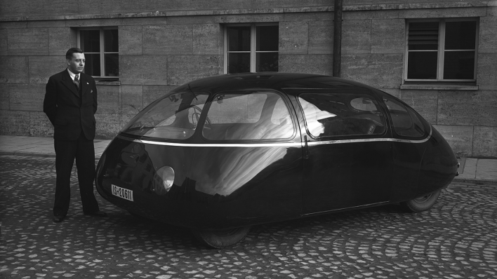 Dr. Michael Hansen, der Vorgesetzte Karl Schlörs, der den AVA-Versuchswagen entwickelte, steht neben dem Schlörwagen Der Wagen wurde aufgrund seiner Form auch "Göttinger Ei" genannt. © Archiv DLR