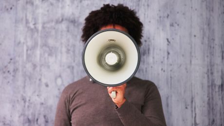 Ein Mann hält ein Megaphone in der Hand © imago images/PantherMedia