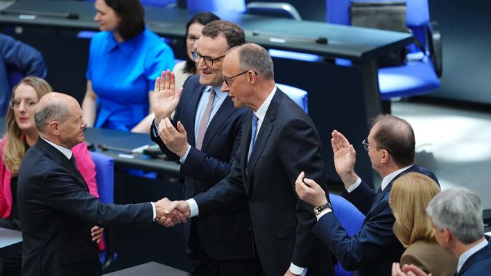 Friedrich Merz ist im zweiten Anlauf im Bundestag zum zehnten Kanzler der Bundesrepublik Deutschland gewählt worden. Der geschäftsführende Bundeskanzler Olaf Scholz (SPD) schüttelt ihm die Hand © Kay Nietfeld/dpa