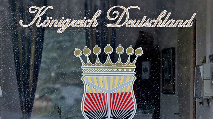 Das Logo des "Königreich Deutschland" prangt am Fenster eines Pförtnerhauses © Jan Woitas/dpa-Zentralbild/dpa