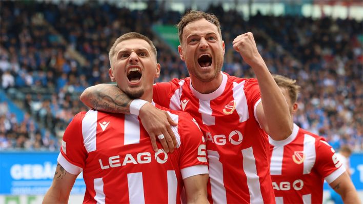 Erik Engelhardt und Timmy Thiele von Energie Cottbus jubeln über den Erfolg gegen den FC Hansa Rostock © IMAGO / Fotostand