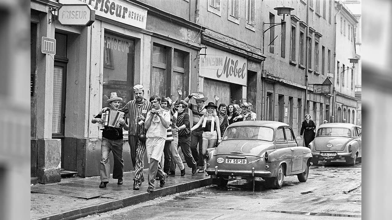 Borchert Christian: Straßenszene mit Faschingsgesellschaft, Dresden, 1981