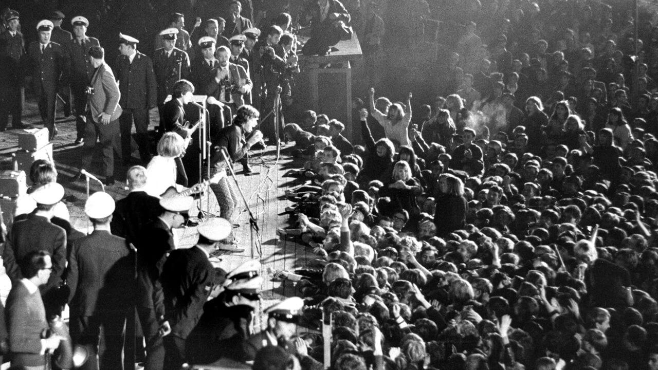 The Rolling Stones in der Waldbühne (15.09.1965). Auf der Bühne zahlreiche Polizisten, rechts Fans, die zur Bühne gestürmt sind. Beim Konzert der Band kam es zu schweren Ausschreitungen zwischen Fans, Ordnern und der Polizei