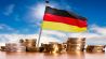 Deutsche Flagge mit Stapeln von Euro Münzen vor blauem Himmel (picture alliance / Klaus Ohlenschläger)
